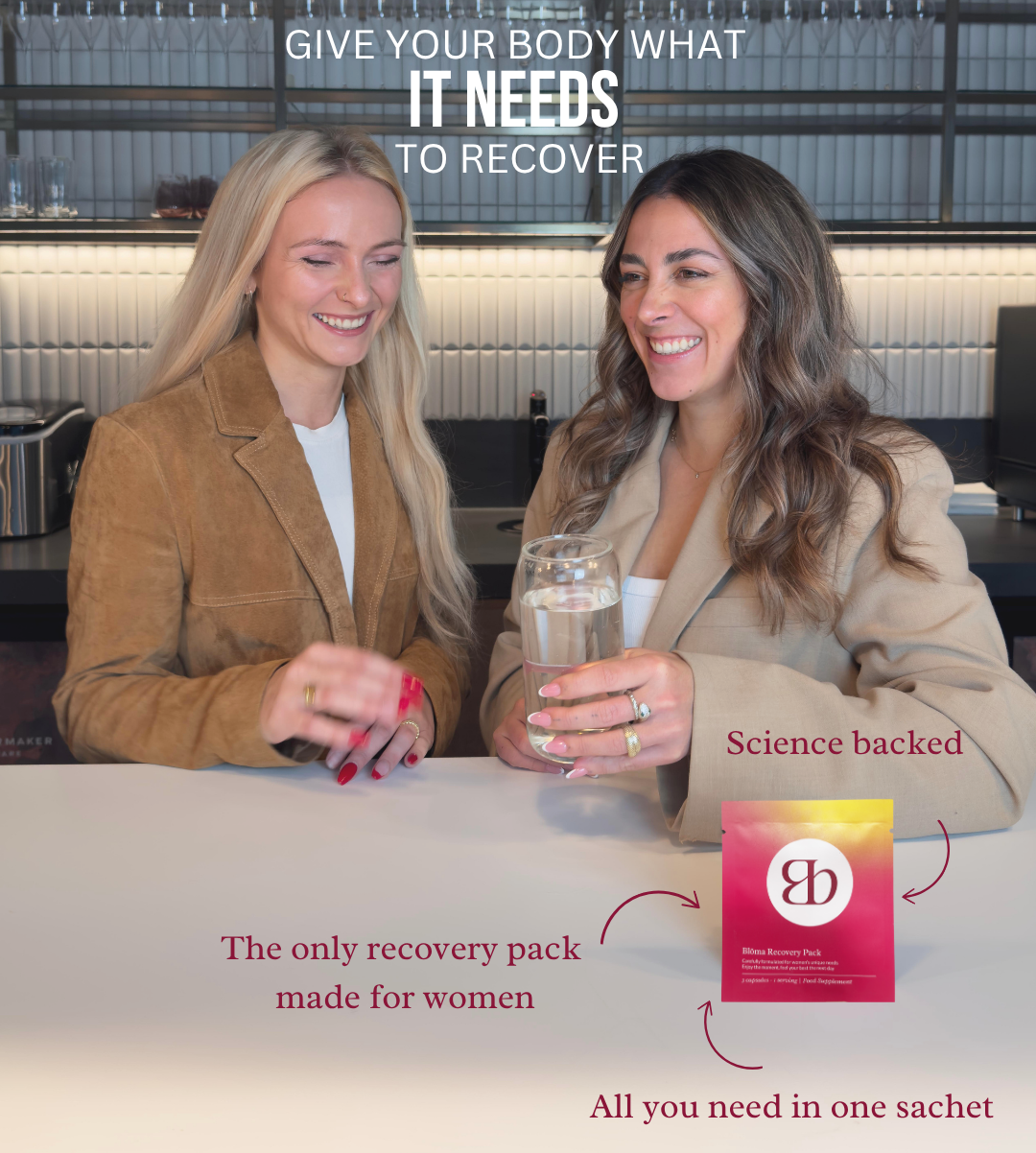 Two women at a kitchen counter smiling as one holds a glass of water beside a Blōma recovery sachet—science-backed support for women.