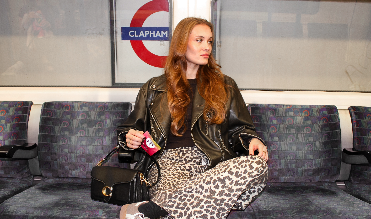 woman holding Blōma Recovery pack while sitting on the london tube at clapham station, ready for a drink and feeling great tomorrow.slider_item_jnHfYR